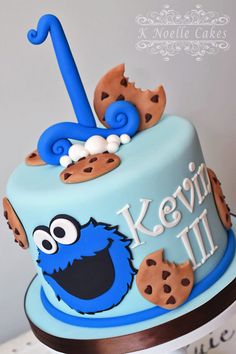 a blue cake decorated with cookies and an icing number one