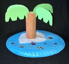 a paper plate with palm trees on it sitting on a black surface next to a cardboard bag