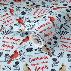 a white wrapping paper with red cardinals and black berries on it, which says cardinals appear when angels are real