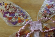 three pieces of plastic with flowers on them sitting on a wooden table next to each other