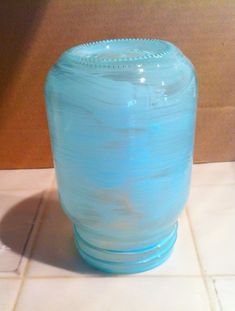 a blue vase sitting on top of a white tile floor