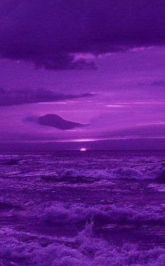 the sky is purple and there are waves in the water