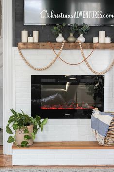 the fireplace is decorated with candles and greenery