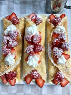 three crepes with strawberries and whipped cream