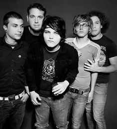 five young men are posing for a black and white photo in front of a dark background