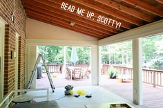 the porch is covered with wood planks and has an open door that says, read me up scotty