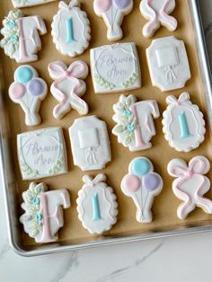 decorated cookies in the shape of baby's first and second names on a cookie sheet