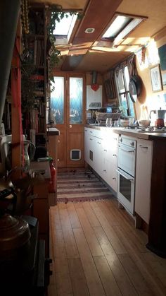 a kitchen with white appliances and wooden floors