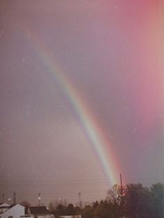 a rainbow appears in the sky over houses