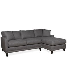 a gray sectional couch sitting on top of a white floor