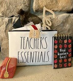 a teacher's essentials bag, notepad and pencil case next to a rock wall