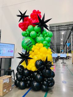 a bunch of balloons in the shape of stars are on display at an indoor event