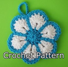 a crocheted flower is shown on a green surface with the words crochet pattern below it