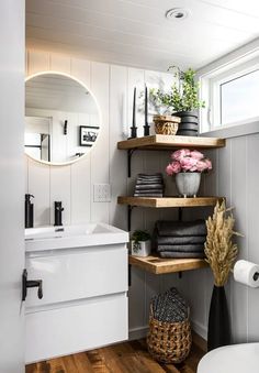 a bathroom with shelving, sink and mirror