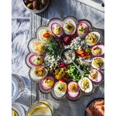 a platter filled with deviled eggs and other food on top of a table