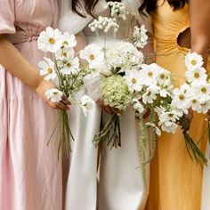 three bridesmaids holding bouquets of white flowers