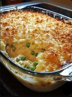 a casserole dish with peas and cheese in it