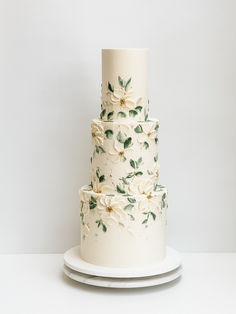 a three tiered cake with white flowers on it