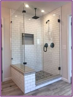 a walk in shower sitting inside of a bathroom next to a door and flooring