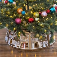 a christmas tree with ornaments and lights on it's top in a tinsel bucket