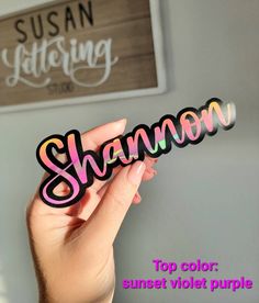 someone holding up a sticker that says, shamon top color sunset violet purple