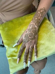 a woman's hand with henna tattoos on her left arm and right hand