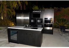 an outdoor kitchen with stainless steel appliances and cabinets