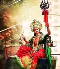 a statue of a woman sitting on top of a wooden bench holding a bow and arrow