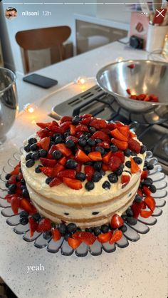 a cake with strawberries and blueberries on it sitting on top of a counter