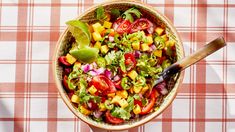 a bowl filled with chopped vegetables on top of a checkered table cloth