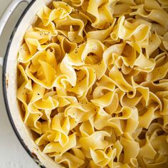 a pot filled with pasta and seasoning sitting on top of a stove