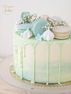 a green cake with white frosting and cookies on top