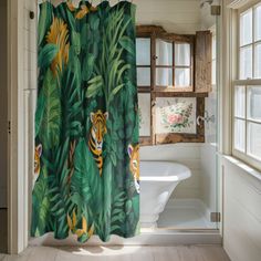 a bathroom with a shower curtain that has tigers on it and green leaves in the background