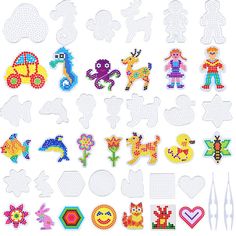 an assortment of cross stitch designs on white paper with scissors and needle markers in the background