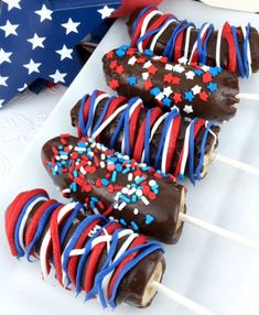 red, white and blue cake pops on a plate with an american flag in the background