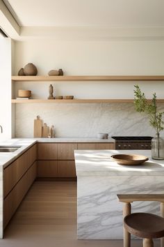 a kitchen with white marble counter tops and wooden cabinetry, along with shelves on the wall