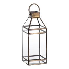 a metal and glass lantern with a handle on the top, sitting against a white background