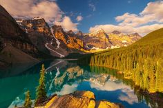 a lake surrounded by mountains and pine trees