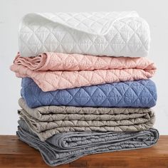 a stack of blankets sitting on top of a wooden table