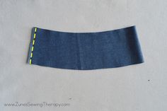 a piece of blue fabric with yellow stitching on the side and one half cut off