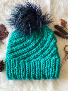 a blue knitted hat with some scissors and other items on top of white fur