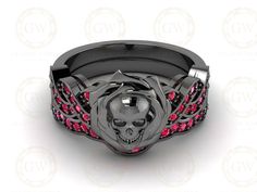 a skull ring with red stones in the center and a black plated band on top