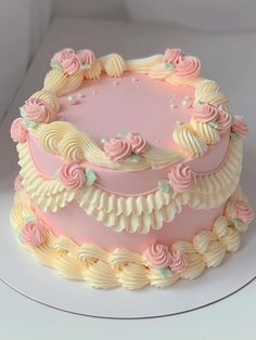 a pink and white cake with flowers on it