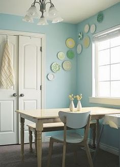 a dining room with blue walls and plates on the wall