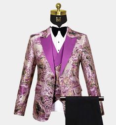 Are you fond of abstract prints? This 3 piece purple and gold tuxedo is just what you are looking for! The pattern is depicted in a beautiful way, with some exotic touches thrown in as well – the entire vibe is quite mysterious, which enhances the appeal of the ensemble. Purple is prominently used in the peaked lapels – the smooth and flawless feel adds to the classiness of the outfit. As mentioned, the pattern is abstract art with thrilling hues of purple and gold and a hint of black at times. James Bond Tuxedo, Prom Fits, Purple Tuxedo, Gold Tuxedo, Tuxedo Prom, Navy Tuxedos, Prom Tuxedo, Black Velvet Bow, Suit Ideas