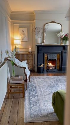 a living room filled with furniture and a fire place next to a mirror on the wall