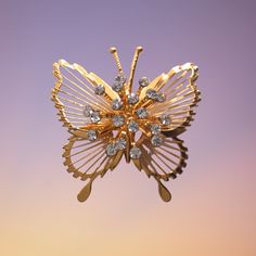 A gold tone frame of a butterfly with gold wire wrapped around it with a center section that looks like a flower with each petal a rhinestone at the end. It is stamped Monet© on the back side. Would make a nice gift for any female. The brooch measures roughly 1.75 inches wide and 1.75 inches tall. Previously owned and in like new condition. Very little if any signs of wear. No missing stones. The pin bar works perfectly. Thanks so much for looking! If you have any questions or concerns please do not hesitate to reach out to me! I usually respond quickly. For other vintage brooches I have for sale please see https://etsy.me/3imy5wn To browse my entire shop please see: https://crazyoldladyjewelry.etsy.com Wire Butterfly, Butterfly Pin, Butterfly Brooch, Gold Butterfly, Gold Wire, A Butterfly, Vintage Brooches, Wire Wrapped, Wire Wrapping