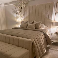 a bedroom with a bed, nightstands and chandelier on the wall behind it