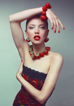 a woman with red lipstick and jewelry on her head is posing for the camera while holding her hands behind her head