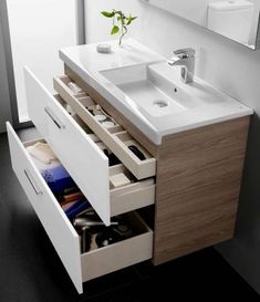 a bathroom vanity with drawers and a sink in the middle is open to reveal its contents